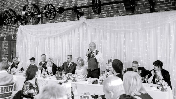 Wedding speeches are enjoyed by family and friends in the wedding barn